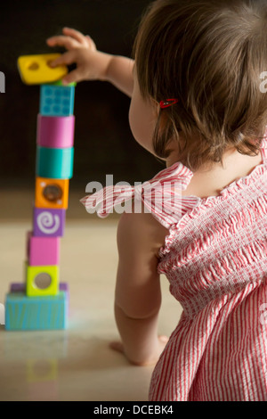 Baby Girl habilement l'équilibre entre des blocs en bois Banque D'Images