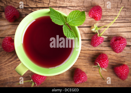 Thé framboise avec de petits fruits sur fond de table en bois. Vue d'en haut Banque D'Images