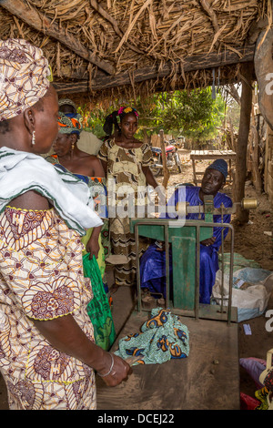 Acheteur de noix de cajou, noix de pesage Fass Njaga Choi, la Gambie. Banque D'Images