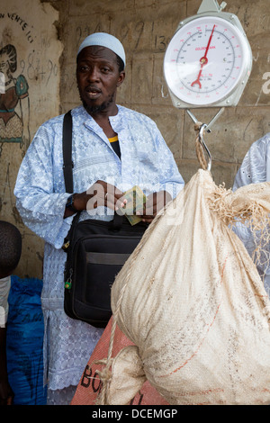 Acheteur de noix de cajou, noix de pesage Fass Njaga Choi, la Gambie. Banque D'Images
