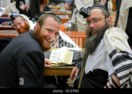 Portrait de 2 hommes juifs religieux alors qu'une 3ème tente de se cacher dans l'arrière-plan. Dans Crown Heights, Brooklyn, New York Banque D'Images