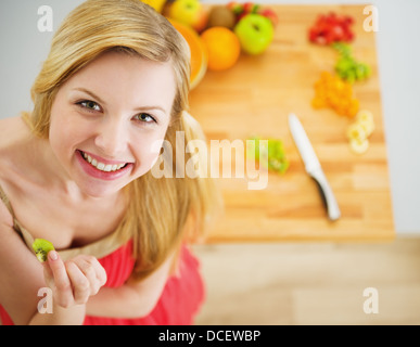 Portrait of smiling young woman making salade de fruits Banque D'Images