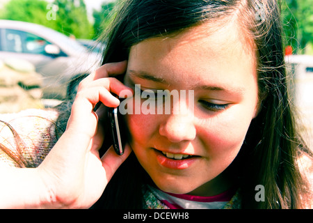 Jeune fille en conversation sur iPhone Banque D'Images