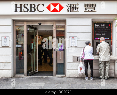 Man and Woman utiliser un guichet automatique en vertu de l'inscription bilingue de la banque HSBC, Gerrard Street, Chinatown, Londres W1 Banque D'Images