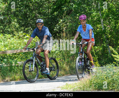 Martha's Vineyard, Massachusetts, USA. 16e Août 2013. Le président des États-Unis Barack Obama va le vélo avec sa fille Malia pendant leurs vacances dans la région de West Tisbury sur Martha's Vineyard, Massachusetts le 16 août 2013. Ils ont été rejoints sur le trajet par la Première Dame (pas sur la photo) et sa fille Sasha Obama (pas sur la photo). Credit : Rick Friedman/CNP/afp photo alliance/Alamy Live News Banque D'Images