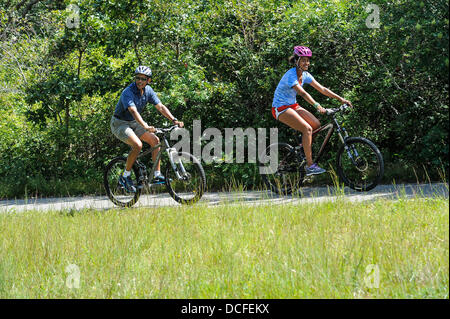 Martha's Vineyard, Massachusetts, USA. 16e Août 2013. Le président des États-Unis Barack Obama va le vélo avec sa fille Malia pendant leurs vacances dans la région de West Tisbury sur Martha's Vineyard, Massachusetts le 16 août 2013. Ils ont été rejoints sur le trajet par la Première Dame (pas sur la photo) et sa fille Sasha Obama (pas sur la photo). Credit : Rick Friedman/CNP/afp photo alliance/Alamy Live News Banque D'Images