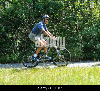 Martha's Vineyard, Massachusetts, USA. 16e Août 2013. Le président des États-Unis Barack Obama va le vélo pendant ses vacances à West Tisbury sur Martha's Vineyard, Massachusetts le 16 août 2013. Il a été rejoint sur le trajet par la Première Dame Michelle Obama et ses filles Malia et Sasha Obama (pas sur la photo). Credit : Rick Friedman/CNP/afp photo alliance/Alamy Live News Banque D'Images