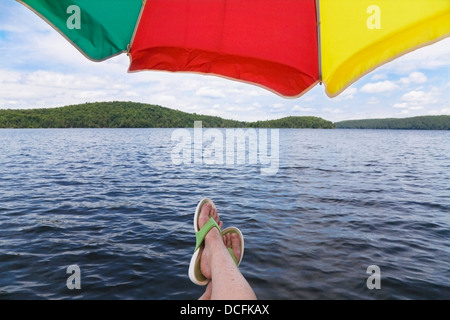 Pieds de femme en tongs sous un parasol, Ontario, Canada Banque D'Images