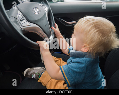 Petit garçon semblant de conduire une voiture Hyundai. Banque D'Images