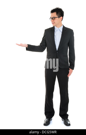 Full body portrait of young handsome smiling asian business man hand showing blank espace vide, isolés sur fond blanc Banque D'Images