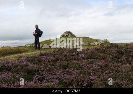 Randonneur Walker, debout près de l'âge du Bronze Penycloddiau Tumulus reconstruit en 2012 Flintshire Pays de Galles Cymru UK GO Banque D'Images