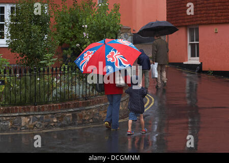 Lyme Regis, Royaume-Uni 17 Août 2013. Les touristes bravent le temps humide. La famille marche le long des rues sous les parasols pour essayer de rester au sec sous l'abri. Crédit: Carolyn Jenkins/Alay Live News Banque D'Images