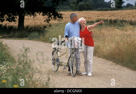 Couple mature sur vélo tandem en campagne Banque D'Images