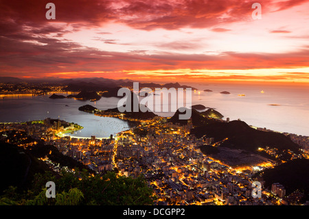 La ville de Rio de Janeiro, Brésil. Le Pain de Sucre, la plage de Botafogo et de quartier vu de Corcovado au lever du soleil, ciel rouge Banque D'Images