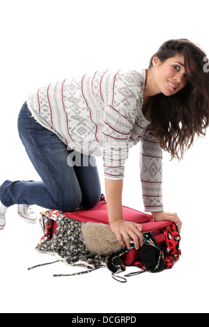 Parution du modèle. Jeune femme un emballage red suitcase Banque D'Images