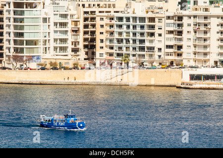 Bateau touristique à travers le port de Marsamxett, Sliema, Malte. Banque D'Images