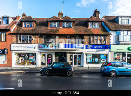 Une variété de boutiques, in sunlit 1930 bâtiments, sur village and Banstead High Street, dans une rue calme dimanche matin à Surrey, Angleterre, Royaume-Uni. Banque D'Images