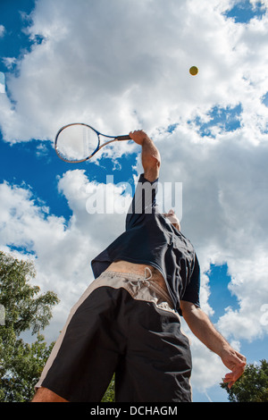 Joueur de tennis contre le beau ciel nuageux sur une journée ensoleillée Banque D'Images
