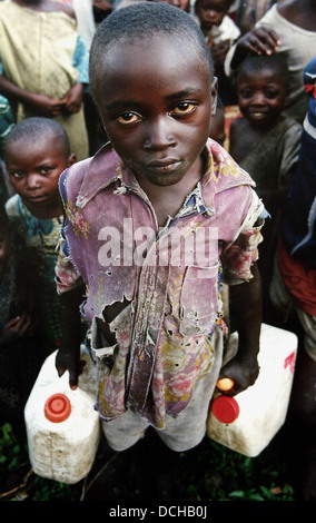 Un jeune garçon recueille l'eau dans un camp de réfugiés à Goma, le Rwanda Banque D'Images