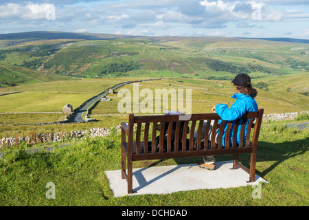 Female hiker sur siège donnant sur Buttertubs passent dans le Parc National des Yorkshire Dales. Yorkshire, Angleterre, Royaume-Uni Banque D'Images