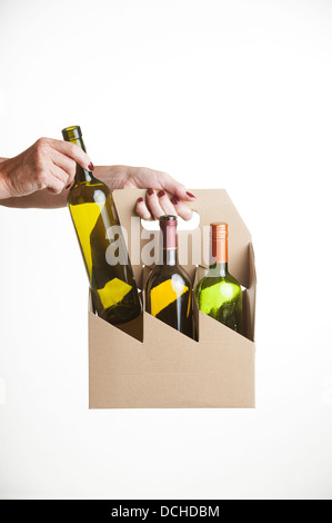 Porte-bouteille de vin fait à partir de carton recyclé. Woman's hand holding Banque D'Images