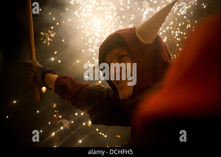 Barcelone, Espagne. Août 18, 2013. 18 août, 2013 - Barcelone, Espagne. Un démon s'exécute au milieu de la pyrotechnie au cours de la célébration de Sant Roc Festival.Correfocs, une vieille tradition catalane où les gens habillés en démons faire exploser des pétards et des fusées éclairantes, prendre part aux célébrations pour le Festival Sant Roc dans le quartier gothique de Barcelone. Crédit : Jordi Boixareu/Alamy Live News Banque D'Images