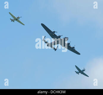 Eastbourne, Sussex, UK. Août 18, 2013. Bombardier Lancaster, accompagné d'un Hawker Hurricane et Supermarine Spitfire de la Battle of Britain Memorial Flight passent au-dessus de la foule © Malcolm Park editorial/Alamy Live News Banque D'Images