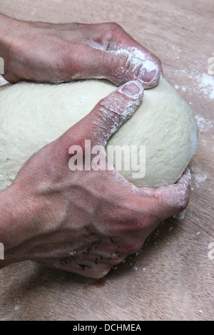 Pâte à pain pétrit Baker dans une boulangerie Banque D'Images