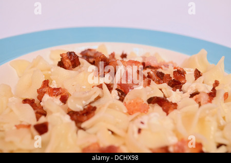 Des pâtes avec du fromage cottage et de bacon sur une plaque bleue Banque D'Images