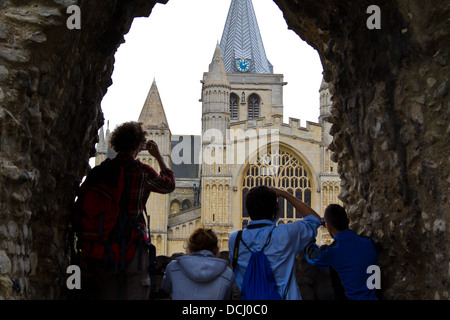 Droit de visiteurs photographier la cathédrale de Rochester par une fenêtre dans un mur de pierre sur un jour d'été gris Banque D'Images