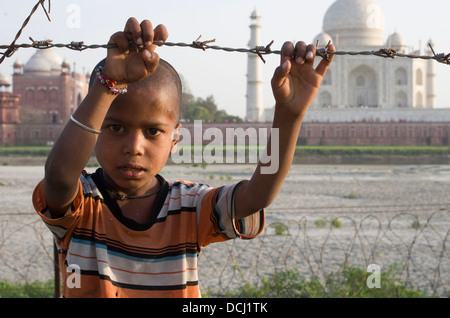 Garçon, barbelés, mausolée en marbre blanc du Taj Mahal - Agra (Inde), site du patrimoine mondial de l'UNESCO Banque D'Images