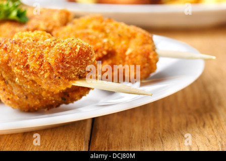 Brochette de poulet frit délicieux sur la plaque blanche sur la table en bois Banque D'Images