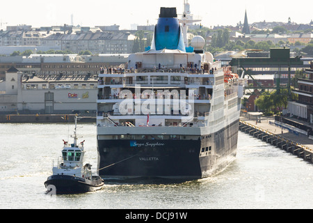 Bateau de croisière 'Saga Sapphire' tiré loin de cruise terminal par un remorqueur, à Stockholm en Suède. Banque D'Images