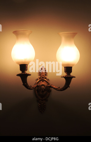 Lampes à gaz traditionnels en faible lumière ambiante, fixée sur un mur dans une maison historique Banque D'Images