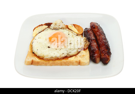 Saucisses et œufs frits sur toast sur une assiette blanche contre isolés Banque D'Images