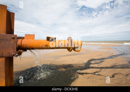 La vidange des eaux usées brutes directement sur la plage à partir d'un tuyau d'eaux usées provenant d'un caravan park à Kilnsea, Banque D'Images