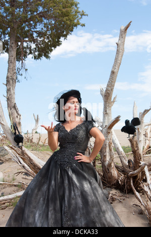 Une belle femme aux cheveux noirs dans une robe de mariage avec les corneilles noires Banque D'Images