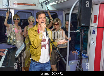 Hambourg, Allemagne. Août 19, 2013. Acteur de premier plan (Pfaff Luk avec microphone) et acteurs musicaux effectuer certaines parties de la nouvelle comédie musicale pendant un communiqué de date pour la nouvelle comédie musicale "ligne S1' dans un S-Bahn (réseau express régional) à Hambourg, Allemagne, 19 août 2013. L'Hamburg encore de fera la création à St Pauli Theatre le 08 septembre 2013. Photo : Georg Wendt/dpa/Alamy Live News Banque D'Images