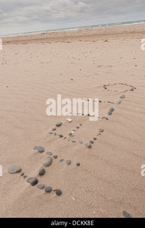 Bonjour parole faite de cailloux faites à marée basse comme les feuilles de la mer la création d'ondes à la plage de sable de sable littoral étendue Banque D'Images