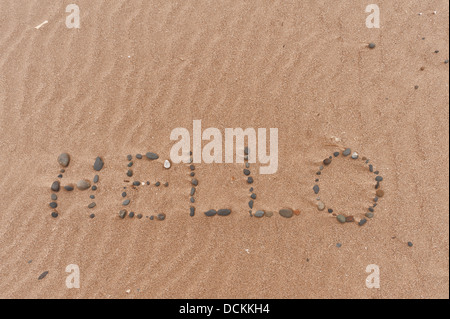 Bonjour parole faite de cailloux faites à marée basse comme les feuilles de la mer la création d'ondes à la plage de sable de sable littoral étendue Banque D'Images