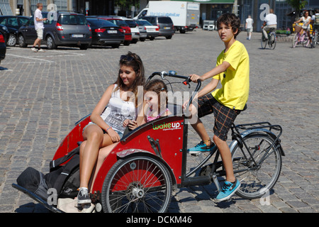 Les jeunes cyclotouristes ou thermocycleurs explorer le port de Copenhague à bord d'un tricycle. Les cyclistes, Copenhague, Danemark. Banque D'Images