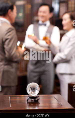 Close up of crystal ball avec des gens d'affaires en arrière-plan Banque D'Images