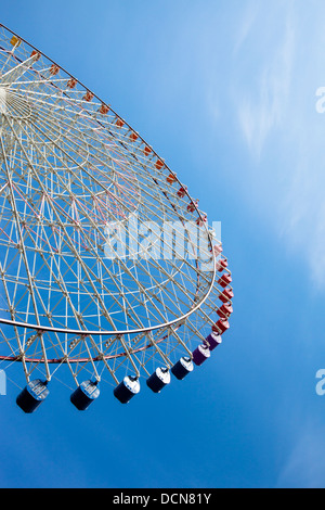 Section semi-circulaire d'une grande roue contre un ciel bleu ensoleillé. Banque D'Images