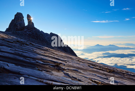 Sunrise Starburst derrière les oreilles d'Âne sur le mont Kinabalu pointe à Sabah Borneo en vue de montagnes nimbées de nuages Banque D'Images