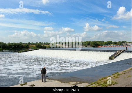 Un homme s'adapter ses cannes à pêche Beeston weir Nottingham England uk Banque D'Images