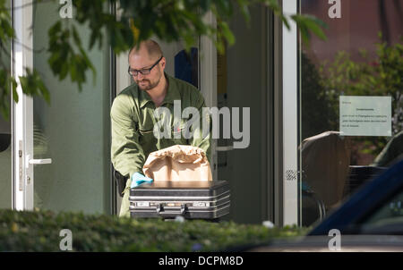 Heidelberg, Allemagne. Août 21, 2013. Un policier assure la preuve lors d'une scène de crime dans un club house à Dossenheim près d'Heidelberg, Allemagne, 21 août 2013. Le 20 août 2013 un homme tué deux hommes, blessé cinq personnes, puis a pris sa propre vie lors d'une réunion. titulaire Photo : UWE ANSPACH/dpa/Alamy Live News Banque D'Images