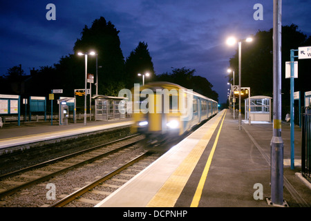 Train arrive à gowerton station sur la ligne de l'ouest du pays de Galles au crépuscule Banque D'Images