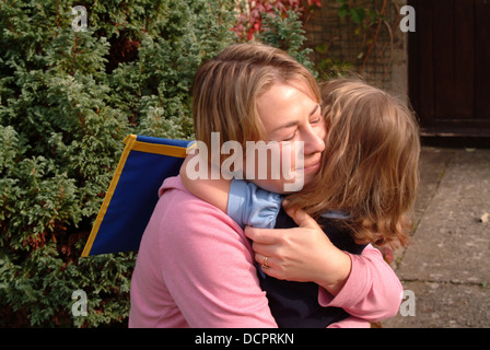 Mother hugging her daughter, première journée à l'école Banque D'Images