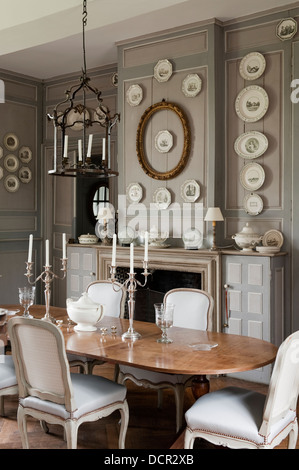 Table et chaises anciennes français dans une élégante salle à manger avec lambris en bois et plaques décoratives Banque D'Images