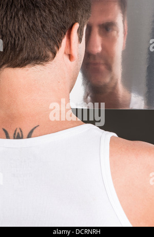 Portrait de l'homme triste et pensif en regardant sa propre image en miroir Banque D'Images